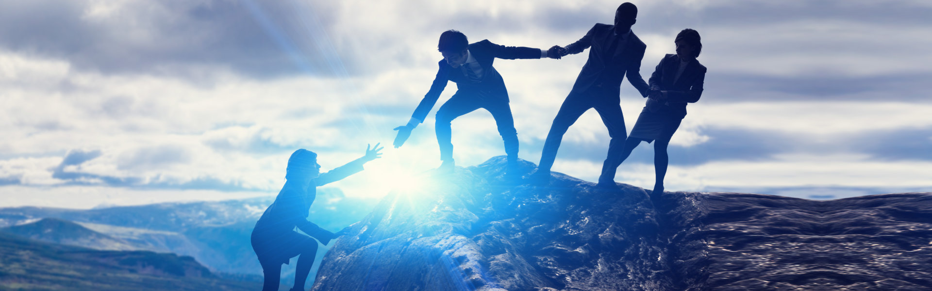 a group of people helping each other on a mountain