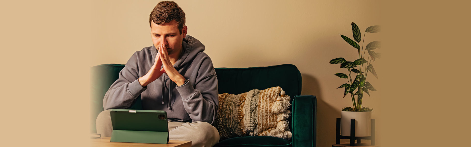 a person sitting on a couch with his hands together